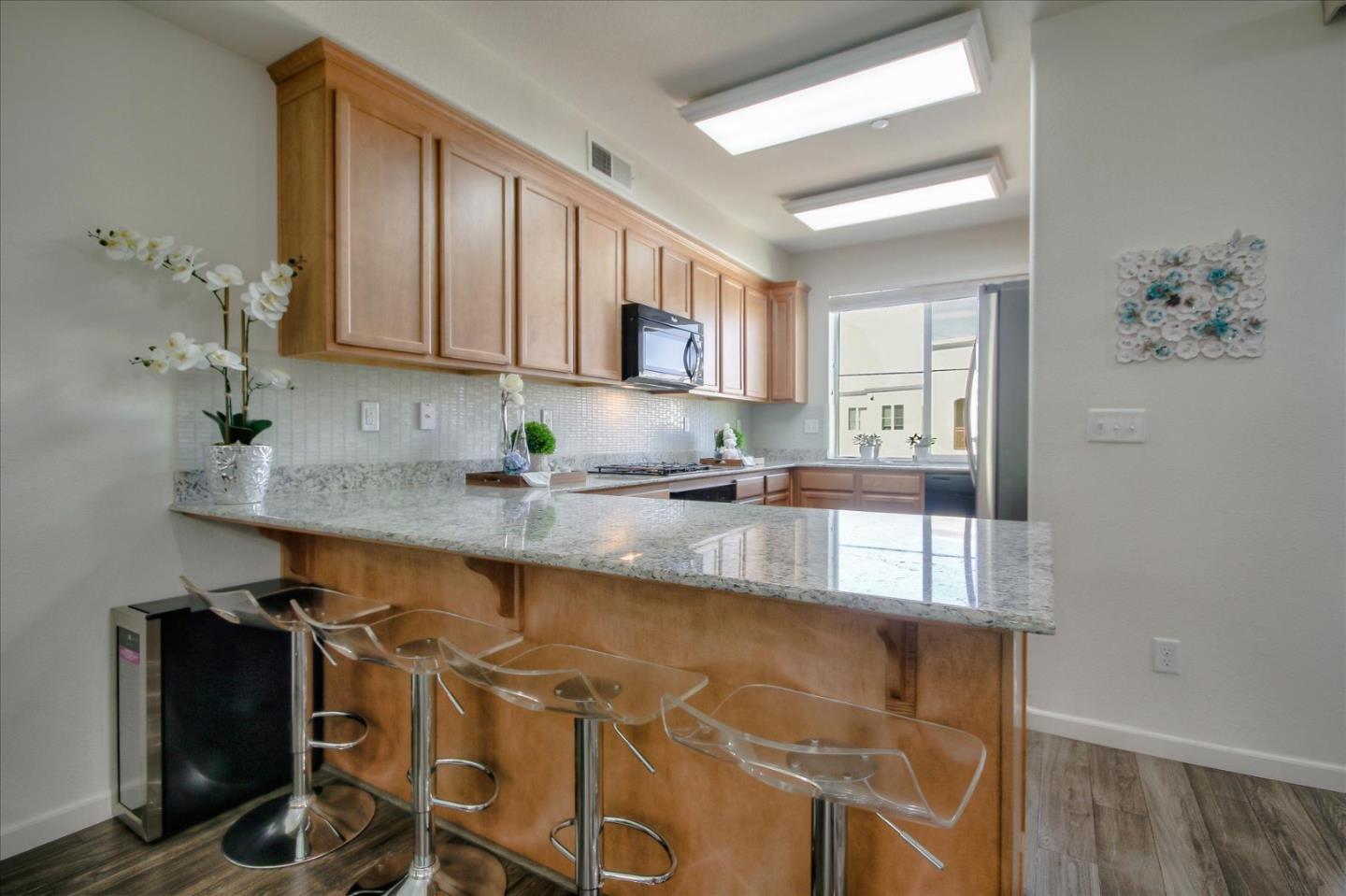 4712 Norris Canyon Road, Unit 202 San Ramon, CA 94583 - Photo 8 of 30 a kitchen with stainless steel appliances granite countertop a sink a stove and a microwave