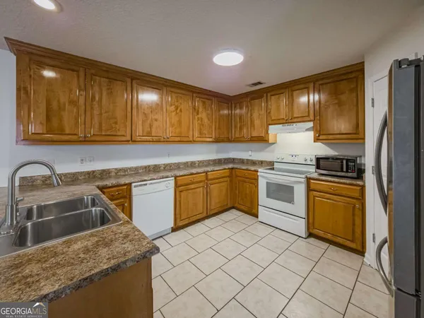 a kitchen with a sink stove and refrigerator