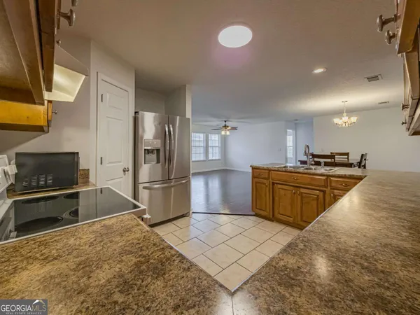 a kitchen with stainless steel appliances granite countertop a stove a sink and a refrigerator