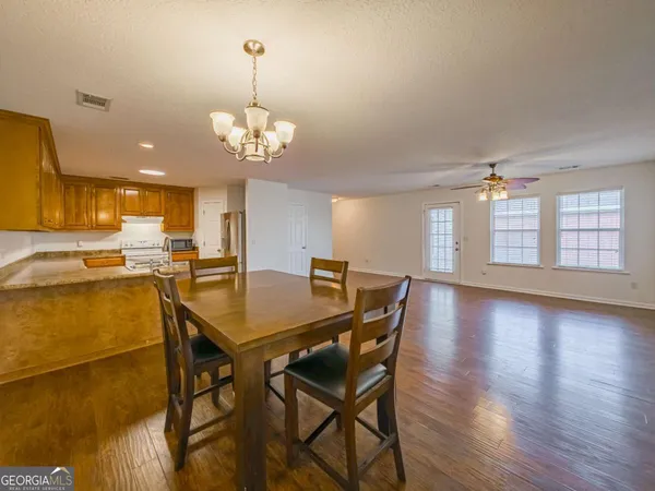 a view of a dining room with furniture and a chandelier