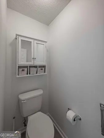 a white toilet sitting next to a white wall