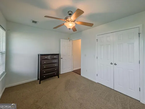a view of an empty room with a ceiling fan and a window