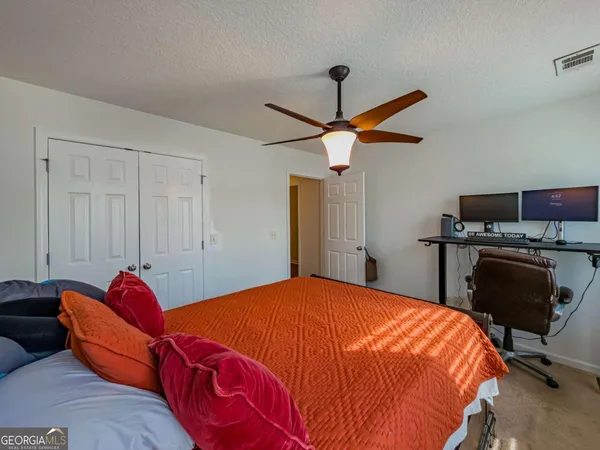 a bedroom with a bed and a ceiling fan
