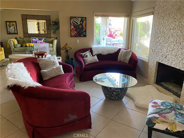 a living room with furniture a fireplace and a large mirror
