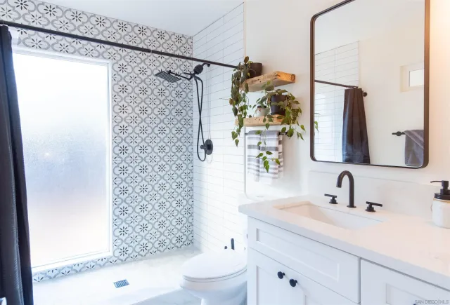a bathroom with a sink toilet vanity and window