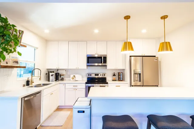 a kitchen with stainless steel appliances a stove microwave sink and cabinets