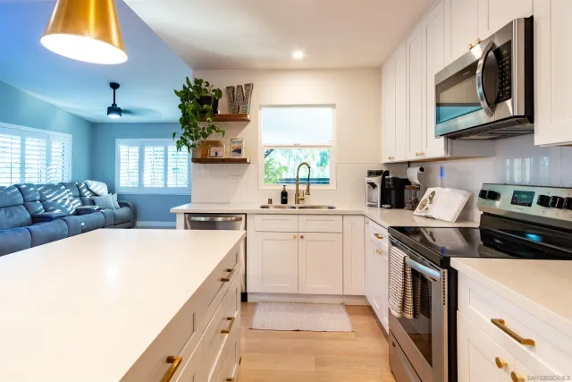 a kitchen with stainless steel appliances a table and chairs in it