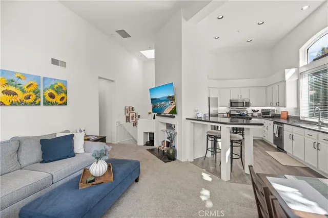 a living room with furniture and kitchen view