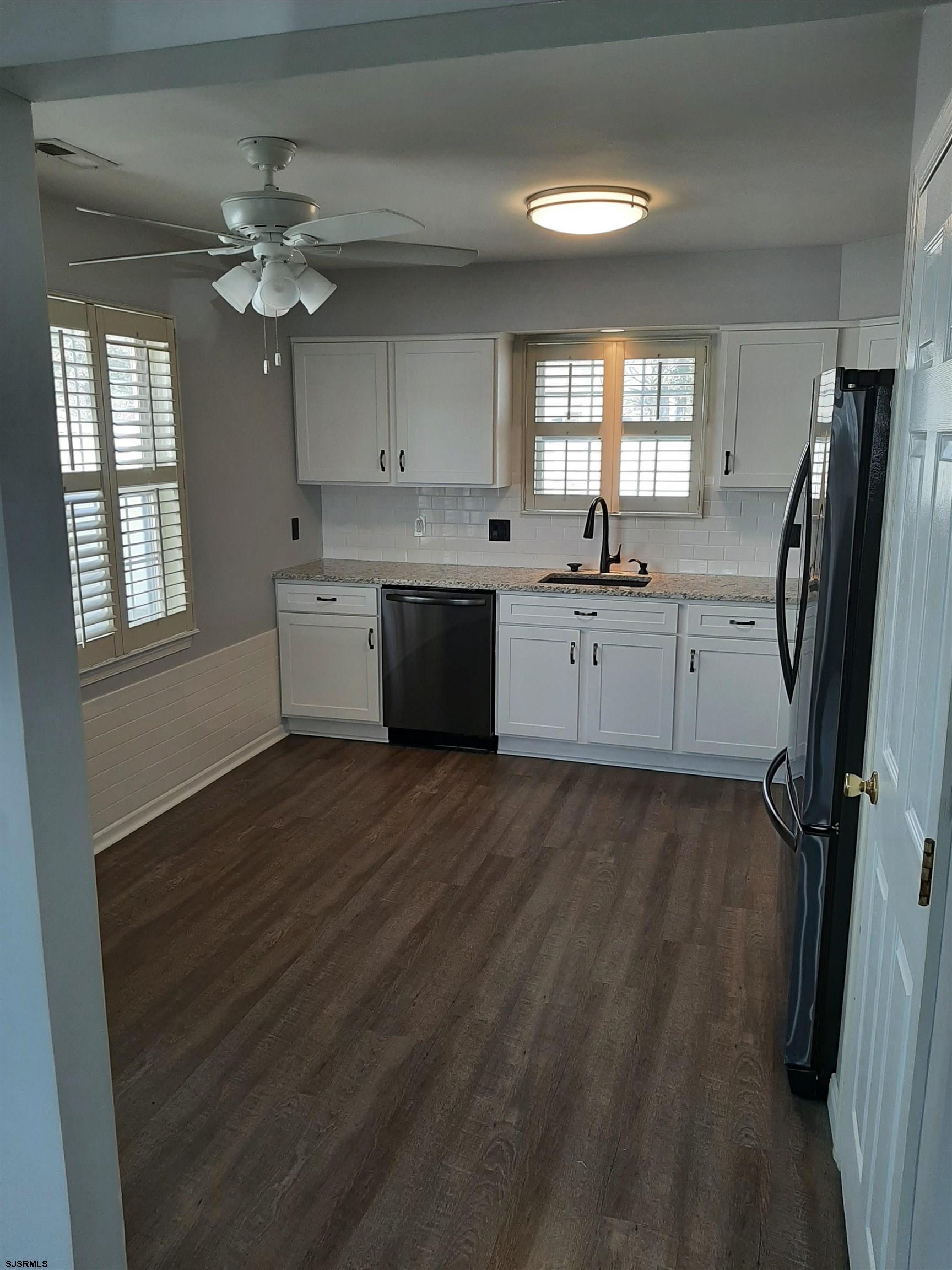 9 Pacific Avenue, Unit 9 Somers Point, NJ 08244 - Photo 5 of 19 a large kitchen with a refrigerator a sink dishwasher a dining table and chairs with wooden floor