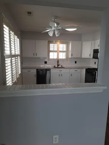 a large kitchen with a window and stainless steel appliances