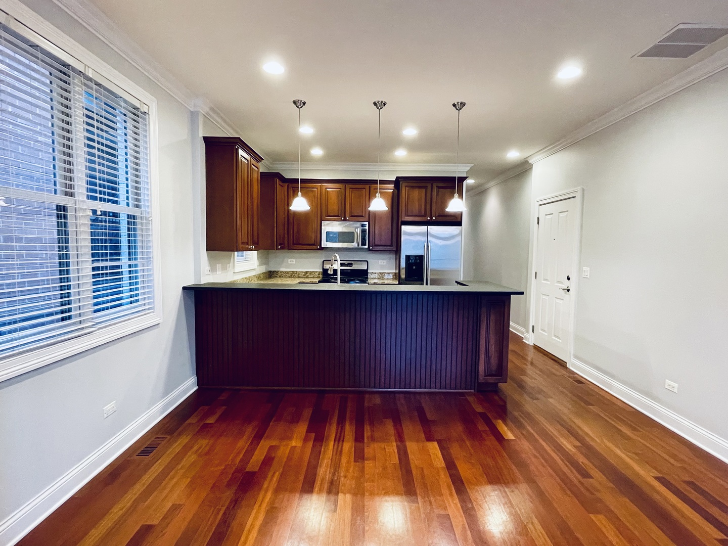 1053 West Cornelia Avenue, Unit 2 Chicago, IL 60657 - Photo 2 of 14 a kitchen with wooden floors and cabinets