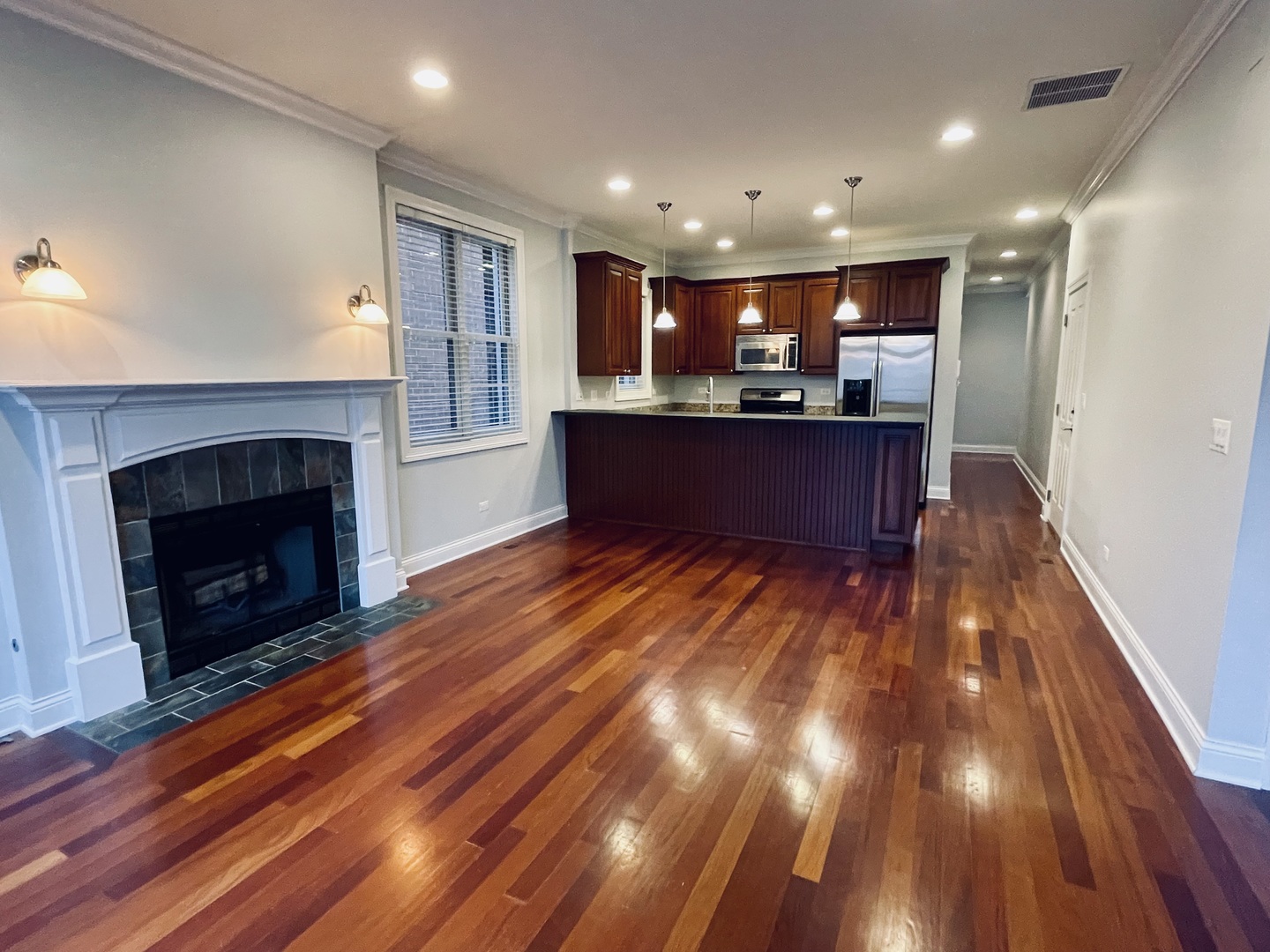 1053 West Cornelia Avenue, Unit 2 Chicago, IL 60657 - Photo 6 of 14 a kitchen with stainless steel appliances granite countertop a refrigerator and a fireplace