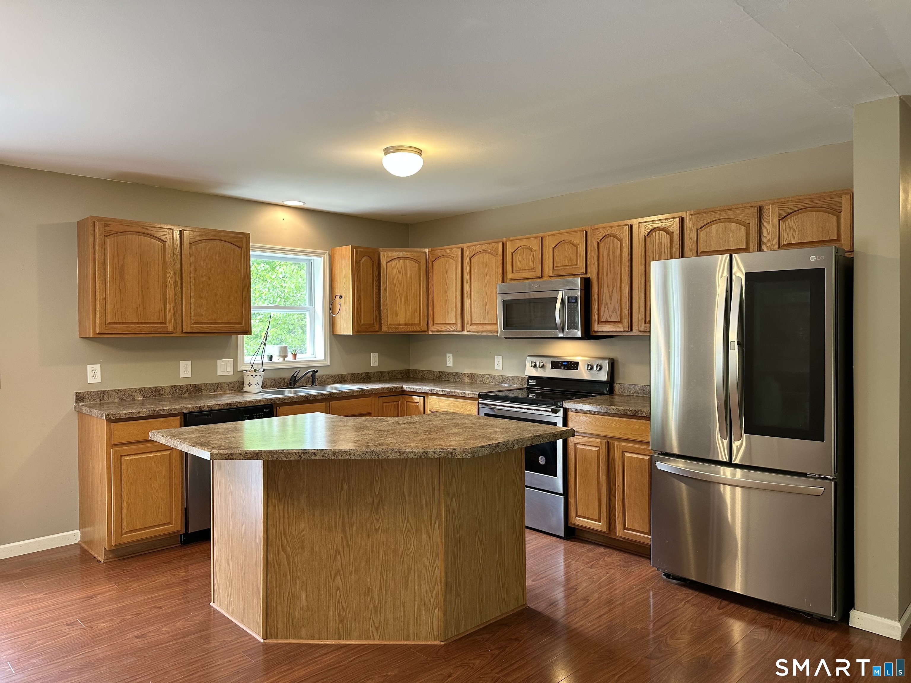 116 Tatnic Hill Road Brooklyn, CT 06234 - Photo 16 of 27 a kitchen with stainless steel appliances granite countertop a stove a sink dishwasher a refrigerator and a microwave oven with wooden floor