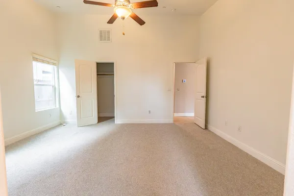 an empty room with a ceiling fan and a window