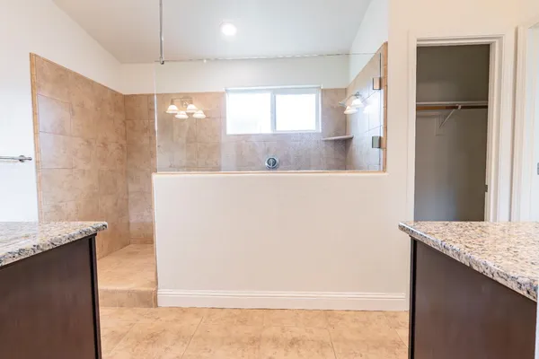 a bathroom with a granite countertop sink and a mirror