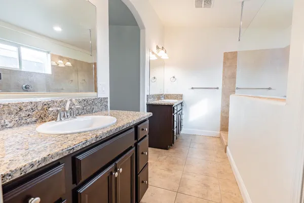 a bathroom with a granite countertop sink and a mirror