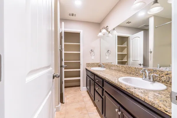 a bathroom with a granite countertop sink a mirror and a shower