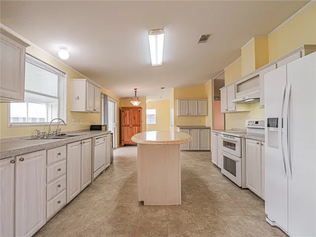 a large kitchen with a large counter top appliances and cabinets