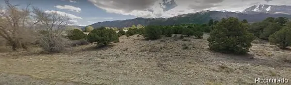 a view of a dry yard with mountains in the background