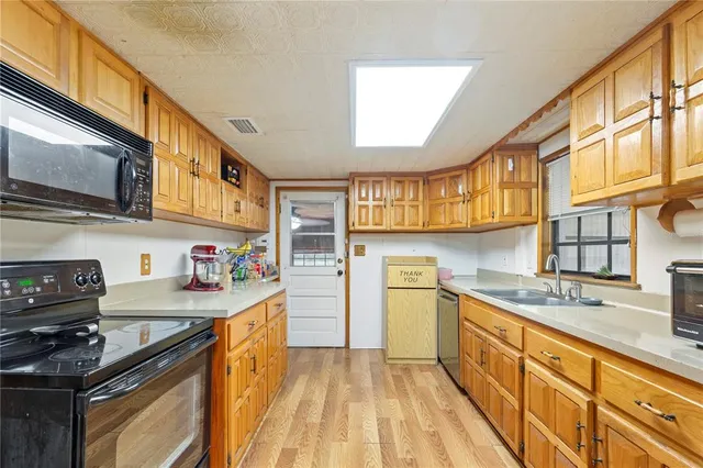 a kitchen with granite countertop cabinets stainless steel appliances and a sink