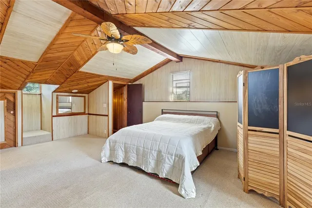 a spacious bedroom with a bed and a chandelier