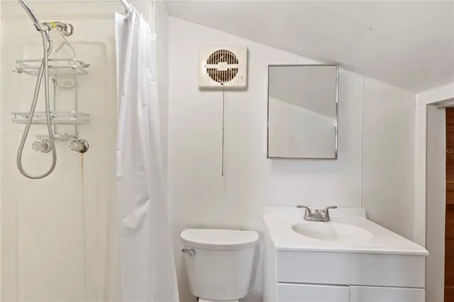 a bathroom with a toilet sink vanity and mirror