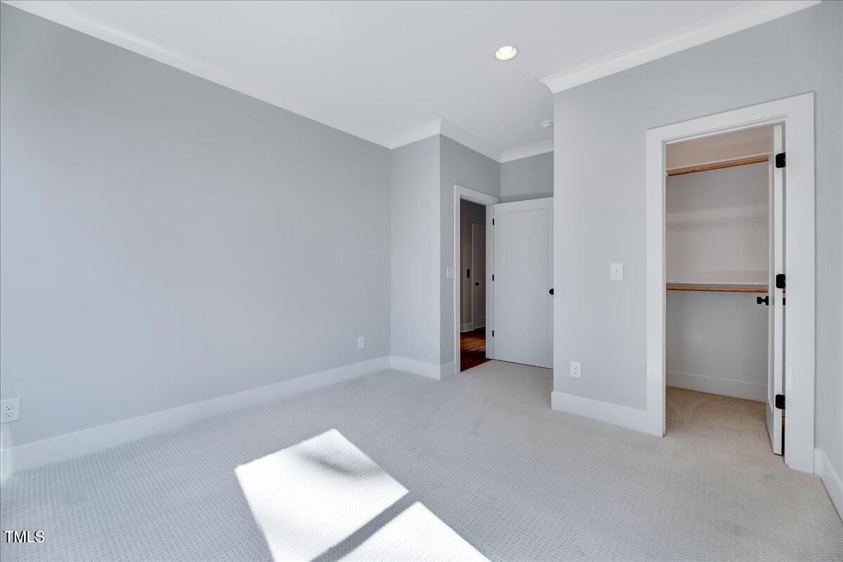 811 Maple Berry Lane, Unit 106 Raleigh, NC 27607 - Photo 22 of 30 an empty room with closet and a hallway