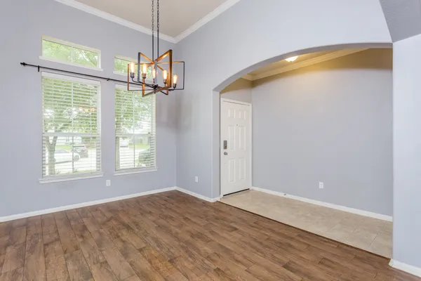 a view of an empty room with glass door and windows