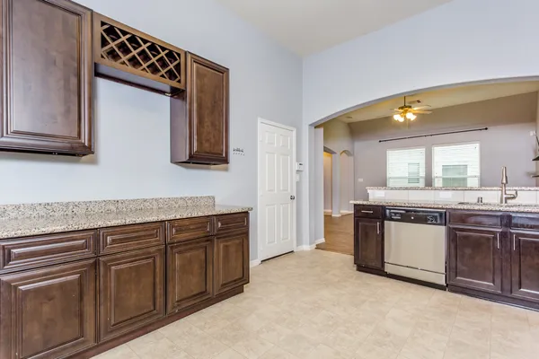 a kitchen with stainless steel appliances granite countertop a stove a sink a microwave a refrigerator and cabinets