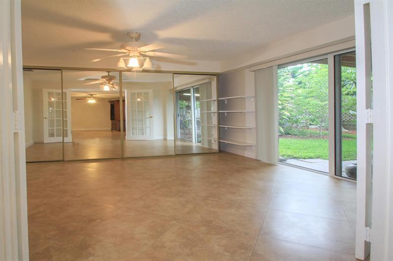 98 Seminole Lane Boca Raton, FL 33487 - Photo 12 of 42 an empty room with wooden floor and windows