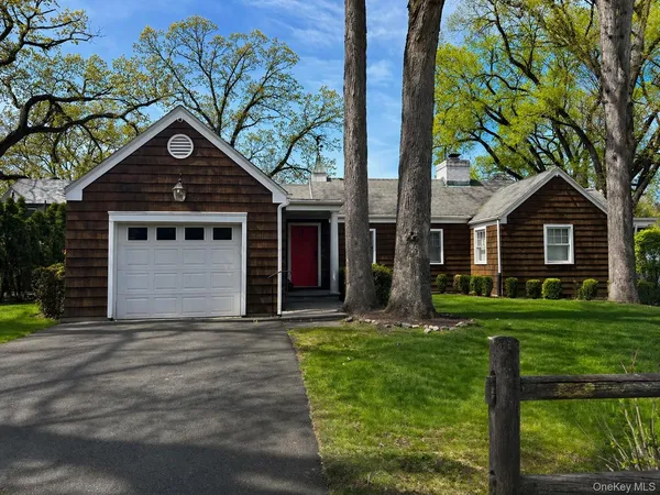 a front view of a house with yard and green space