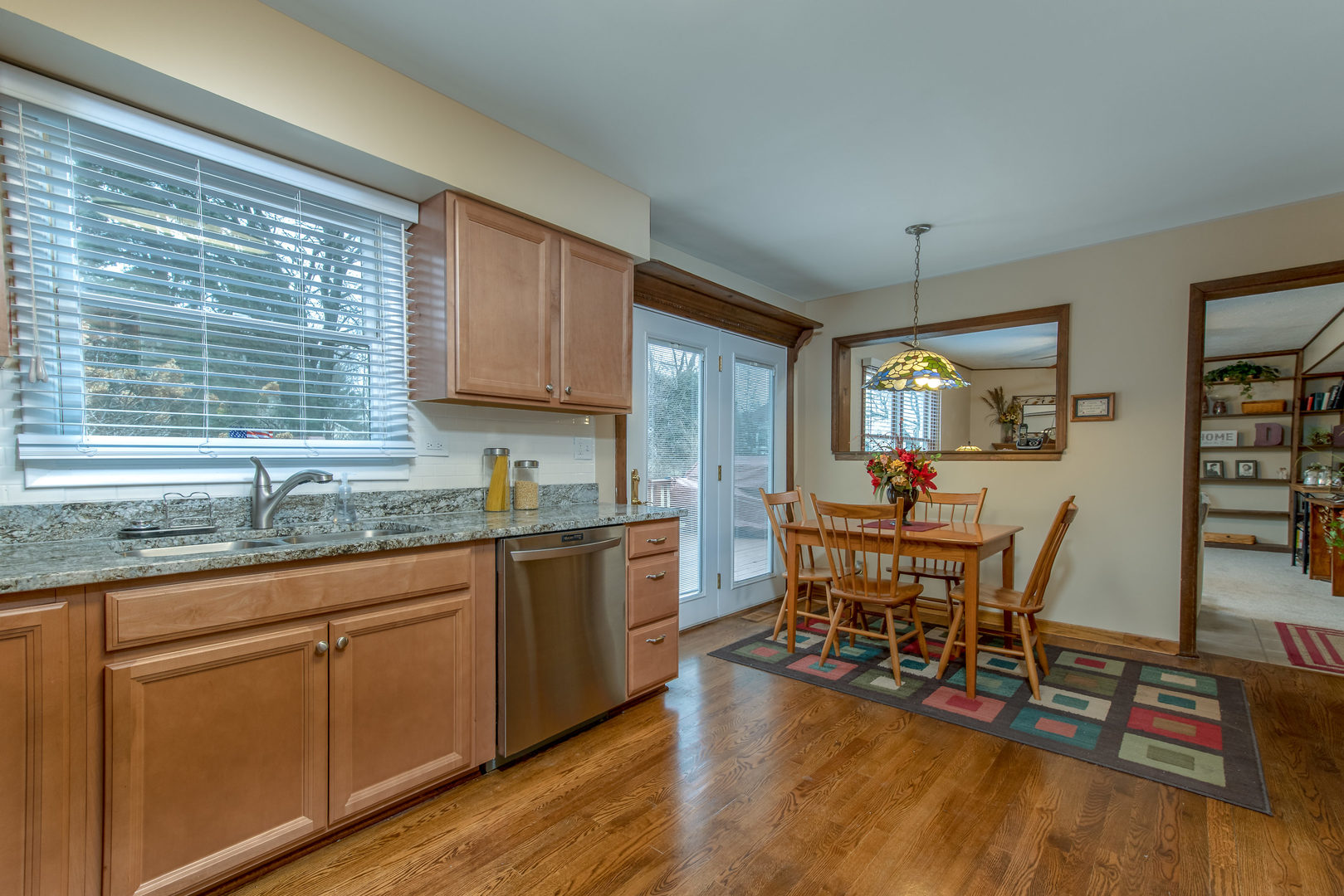 2105 Countryside Circle Naperville, IL 60565 - Photo 8 of 26 a kitchen with stainless steel appliances granite countertop wooden floor a dining table and chairs