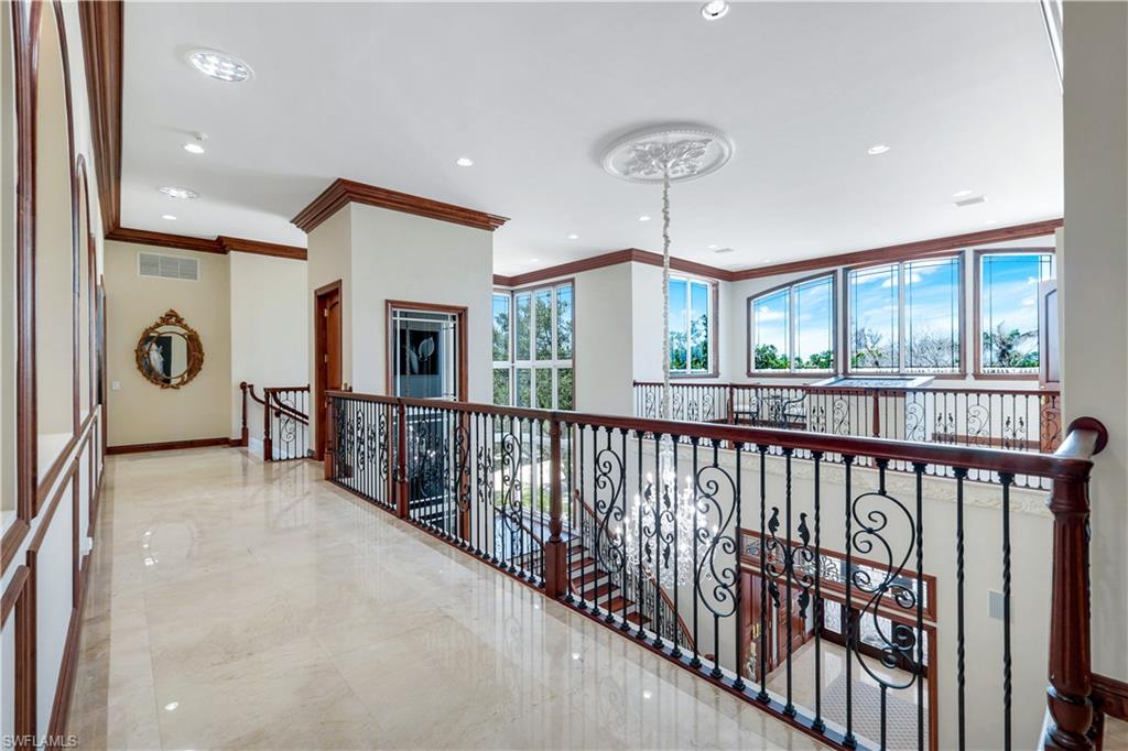 7159 Manasota Key Road Englewood, FL 34223 - Photo 21 of 50 Hall with ornamental molding, recessed lighting, marble tiled floors, a chandelier, and an upstairs landing