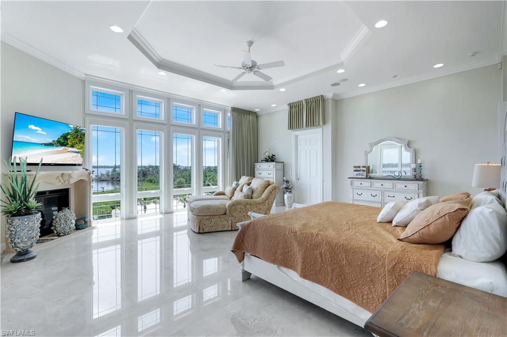 7159 Manasota Key Road Englewood, FL 34223 - Photo 23 of 50 Bedroom with a raised ceiling, ornamental molding, a fireplace, ceiling fan, and recessed lighting
