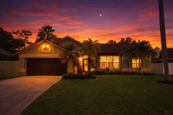 a front view of a house with a garden and yard