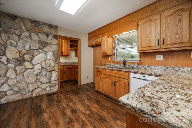 a kitchen with granite countertop a sink and a refrigerator