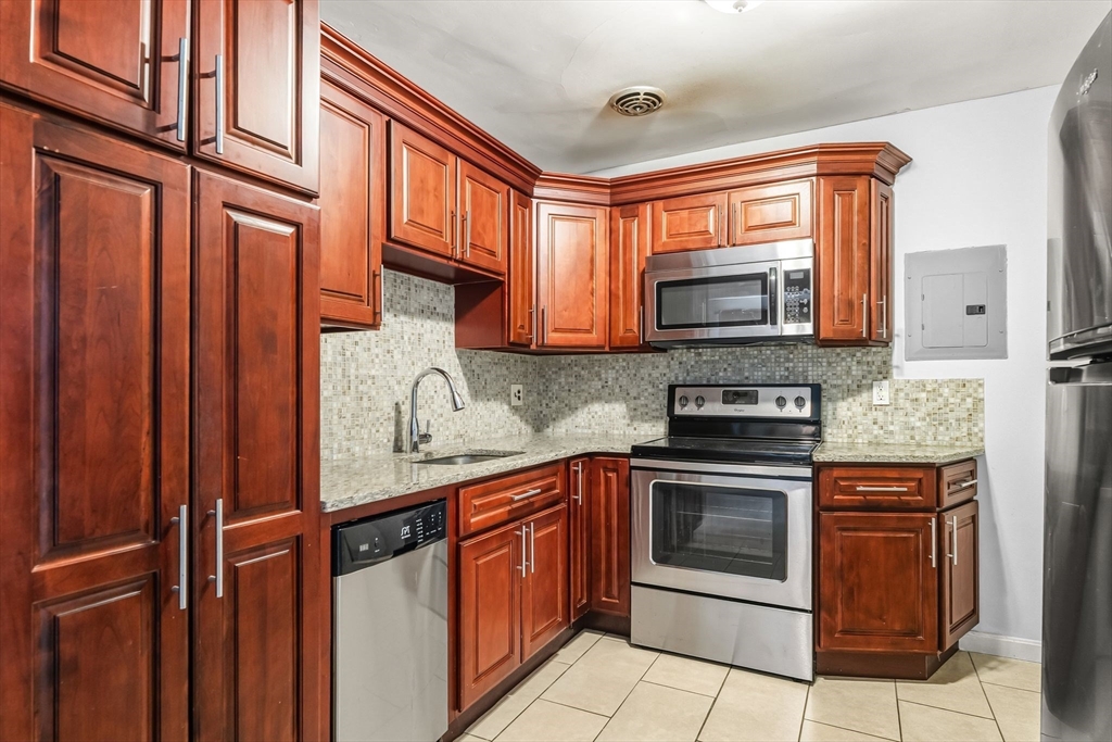a kitchen with stainless steel appliances granite countertop a refrigerator and a stove top oven