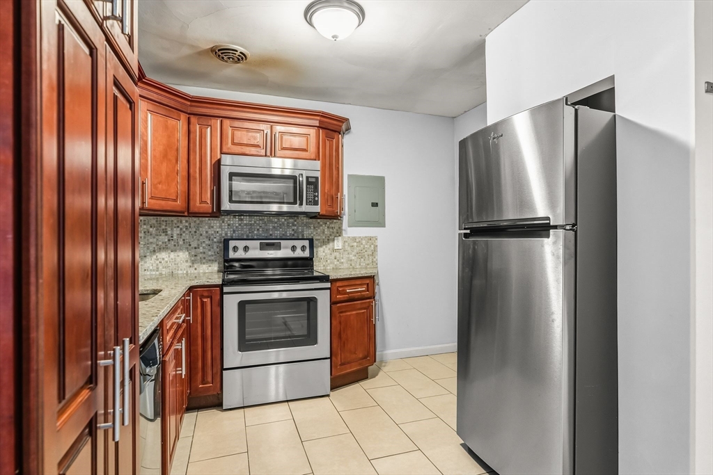 133 Warren Street, Unit 3 Watertown, MA 02472 - Photo 12 of 22 a kitchen with stainless steel appliances granite countertop a refrigerator stove and sink