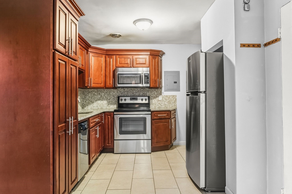 133 Warren Street, Unit 3 Watertown, MA 02472 - Photo 13 of 22 a kitchen with stainless steel appliances a refrigerator stove and sink