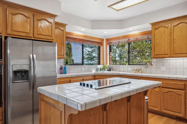 a kitchen with stainless steel appliances granite countertop a sink and a refrigerator