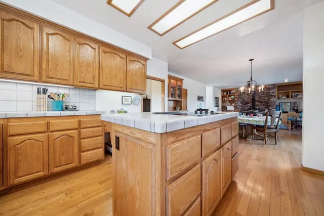 a kitchen with sink cabinets and dining table chairs