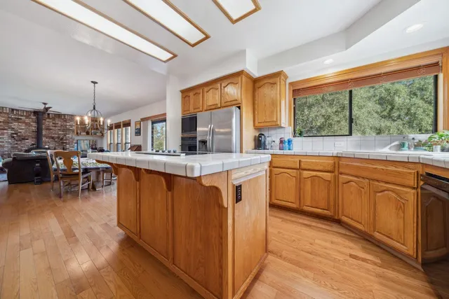 a kitchen with stainless steel appliances granite countertop sink stove and wooden cabinets