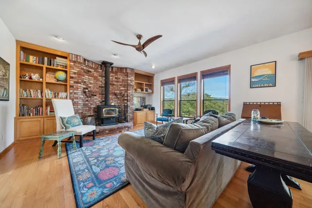 a living room with fireplace furniture and a large window