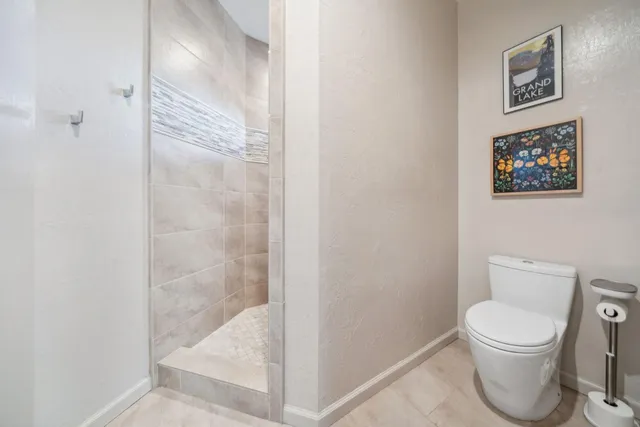 a bathroom with a toilet and a shower