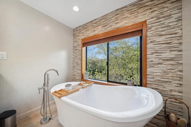 a white bath tub sitting in a bathroom next to a window