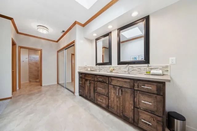 a spacious bathroom with a double vanity sink and a mirror