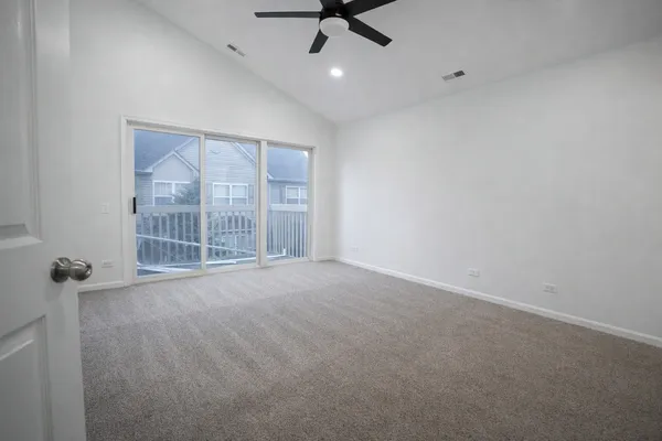 en empty room with windows and ceiling fan