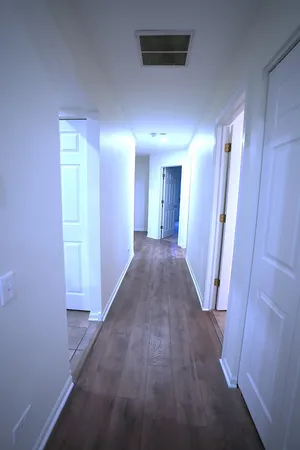 a view of a hallway with wooden floor