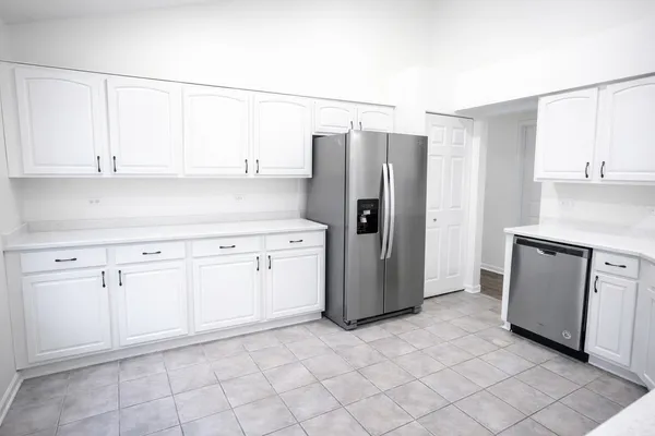 a kitchen with a refrigerator sink stove and cabinets