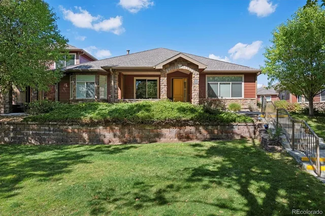 a front view of a house with a yard and potted plants